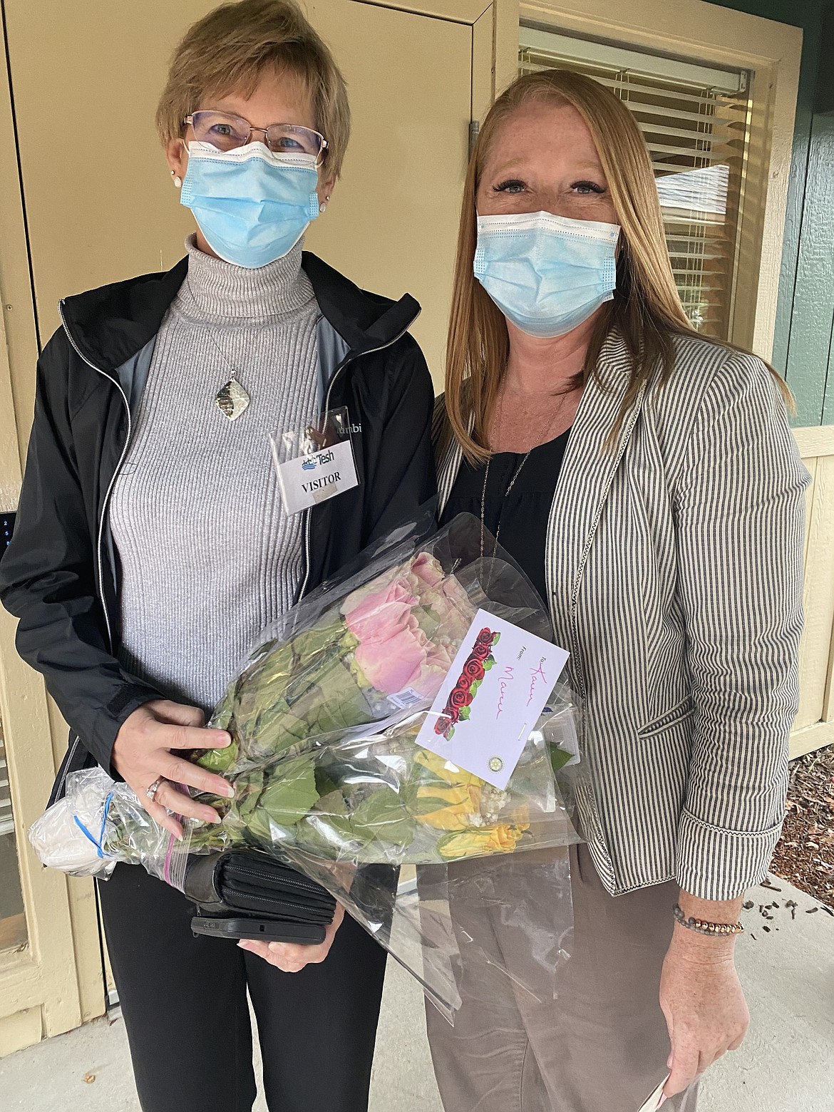 Marcee Hartzell presents roses to her board chair Karen Alberts. Many board members have had to step back because of COVID's effect on other areas of life, Hartzell said.