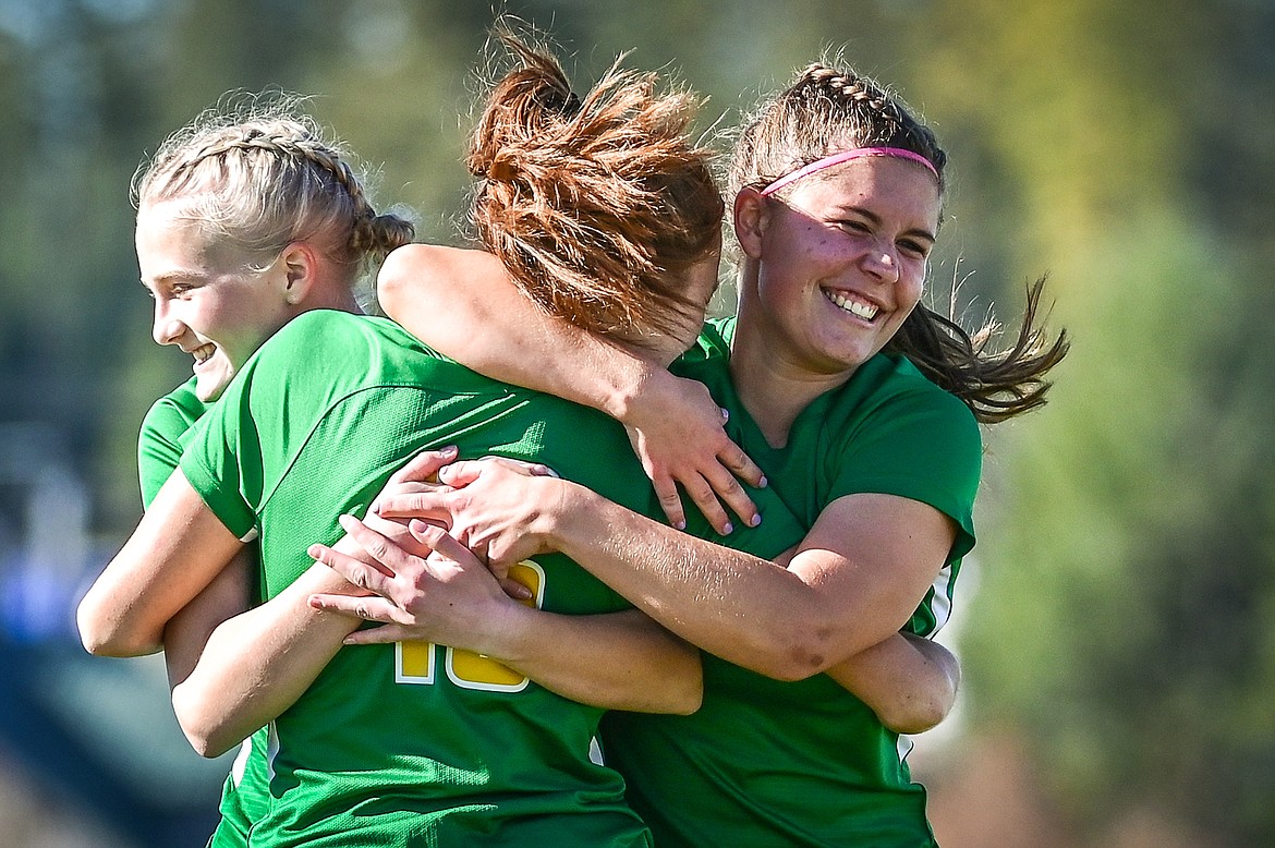 From left, Whitefish's Isabelle Cooke (5), Adrienne Healy (16) and Emma Barron (11) celebrate after Healy's goal in the first half against Loyola Sacred Heart at Smith Fields on Saturday, Oct. 16. (Casey Kreider/Daily Inter Lake)