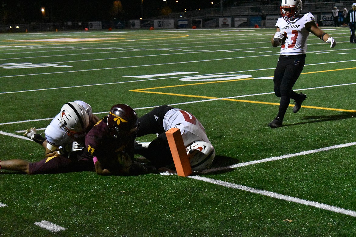 It took two defenders to bring down senior Sergio Guzman (11) at the corner of the end zone Friday.