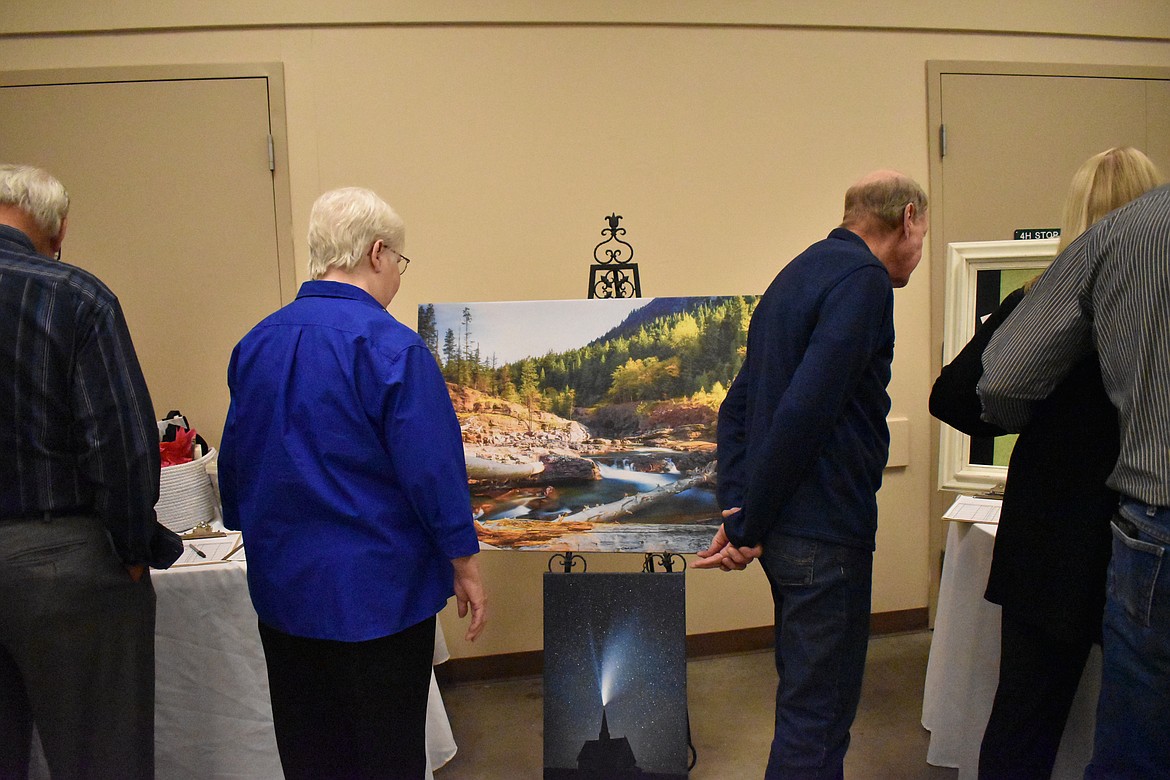 Attendees view some items sold in a silent auction prior to dinner at the Youth Dynamics fundraiser.