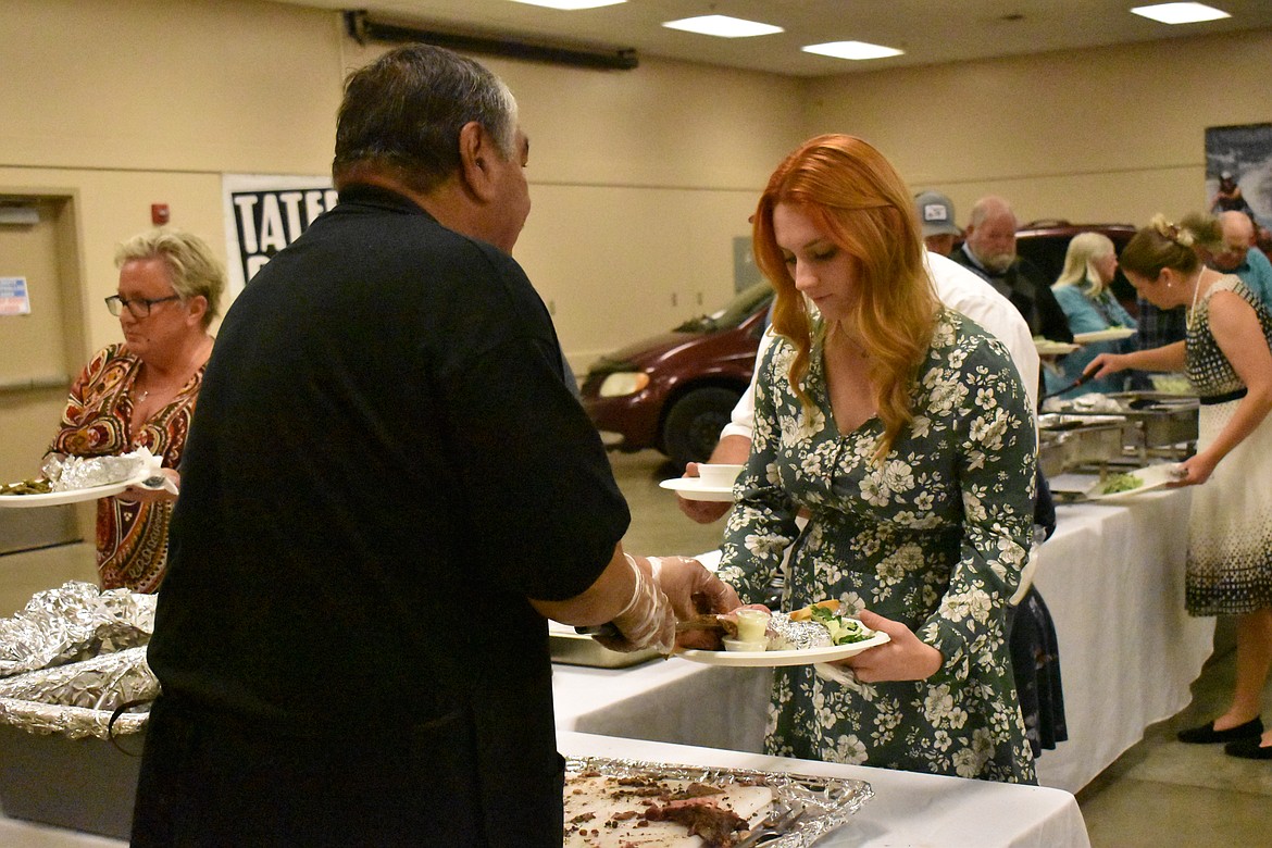 Jim Duzon serves prime rib to one of the fundraiser attendees.