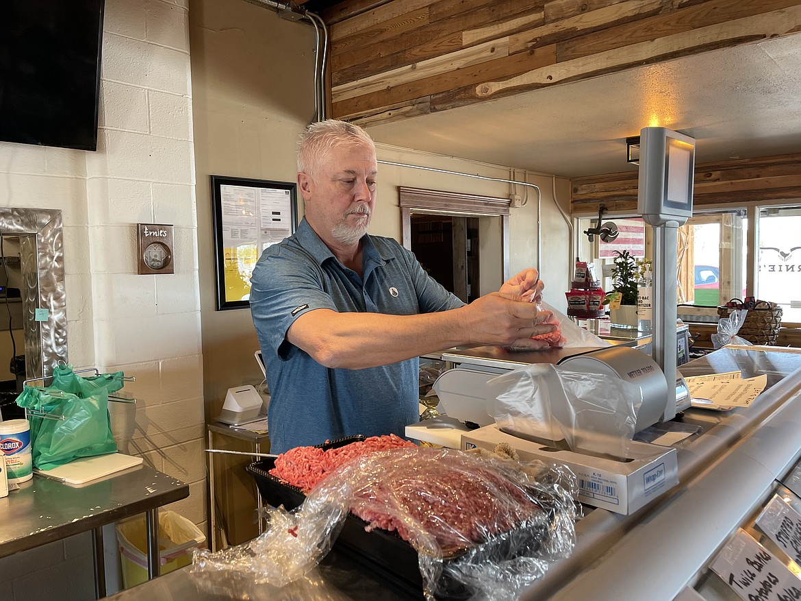 Keith Tunstall weighs ground beef for a customer at the butcher shop he co-owns with Ernie Lang, Ernie’s Quality Meats and Wine.