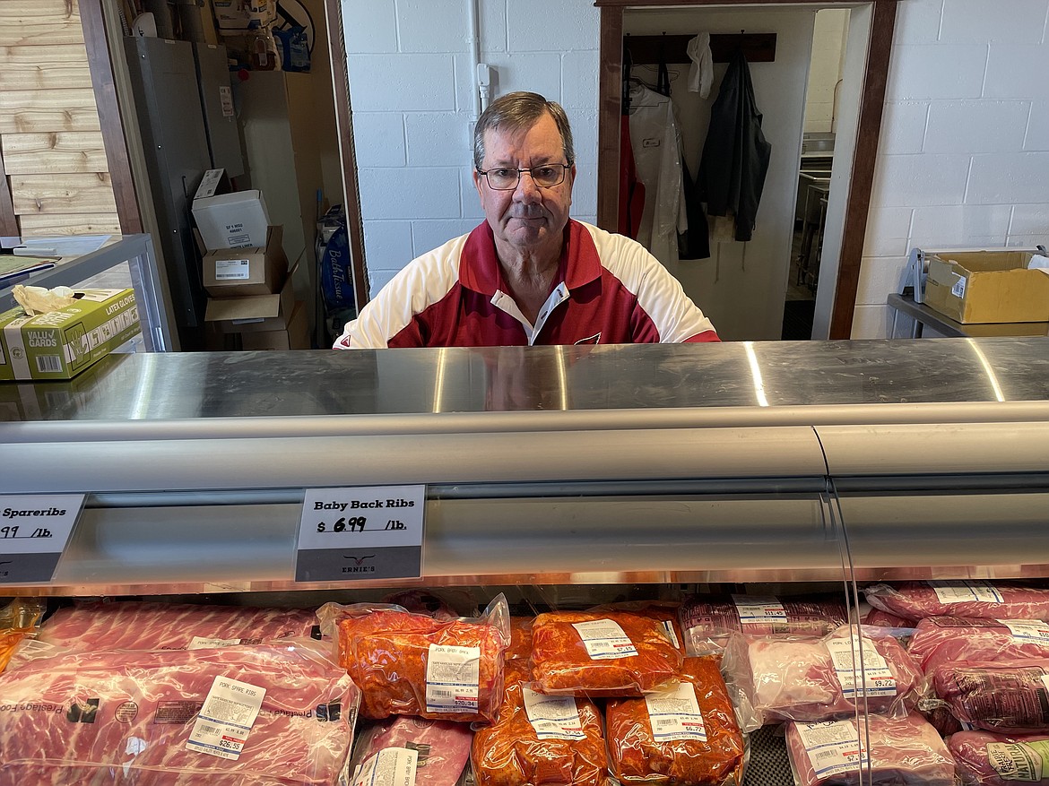 Veteran butcher and meat cutter Ernie Lang stands behind a display case of Ernie’s Quality Meats and Wine.