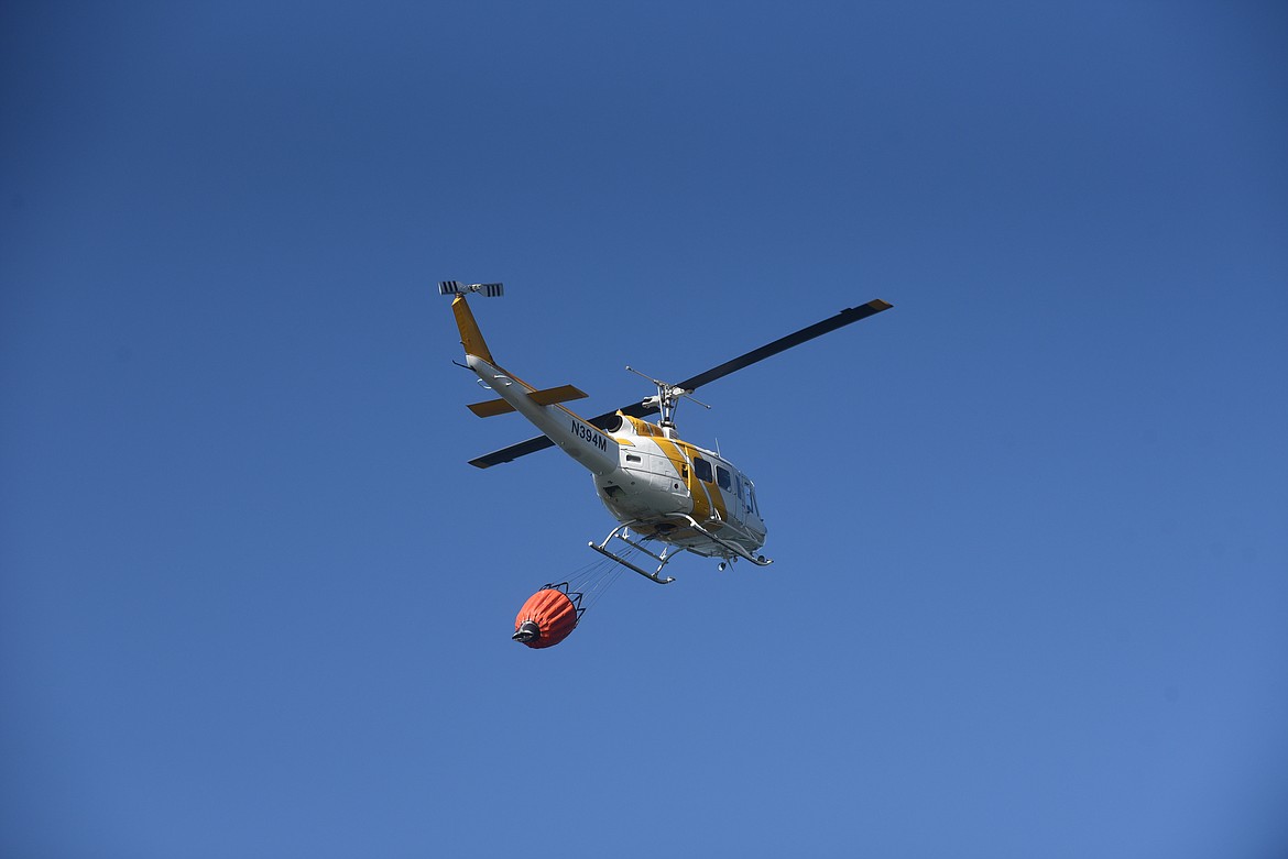 A helicopter prepares to pick up water from Foys Lake to help fight the Patrick Creek Fire Monday afternoon. (Scott Shindledecker/Daily Inter Lake)