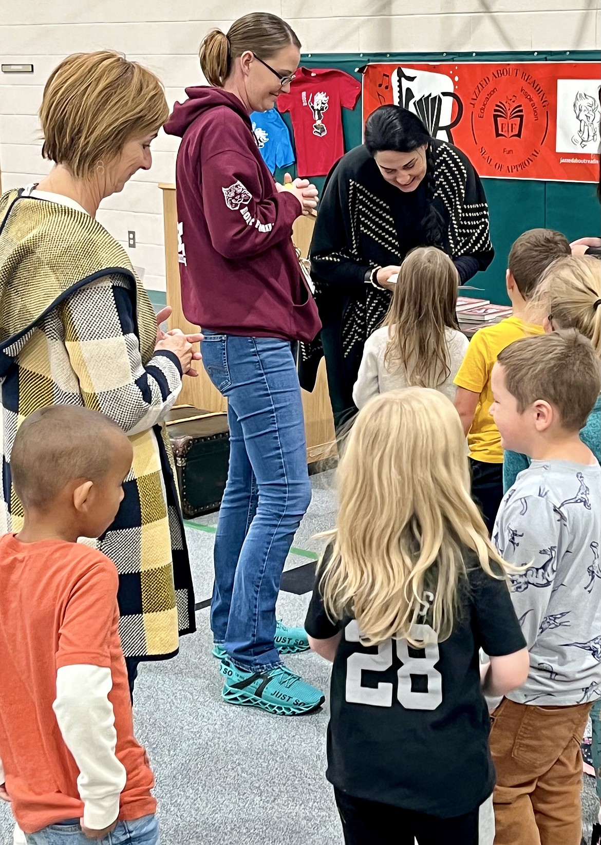 From left, Leslie Bjerke, Allie Anderton and Annie Winston meet with kindergartners at Betty Kiefer Elementary School in Rathdrum on Thursday for a reading rally through Jazzed About Reading, a service organization and non-profit reading incentive program started in 2018 by Winston. Winston, a local children's author, signs her book, “Daniel Boone and the Battle of Boonesborough: Admiral Wright’s Heroical Storicals." Photo courtesy of Annie Winston