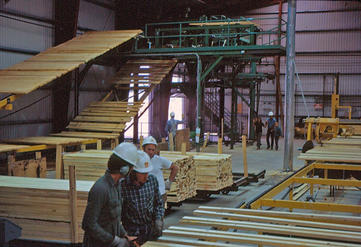 Machinery is still painted Georgia Pacific green but employees are seen wearing Louisiana-Pacific hard hats. During 1973 when the mill changed owners, people were given tours of the plant. The photo was taken by Dale Sargent.
