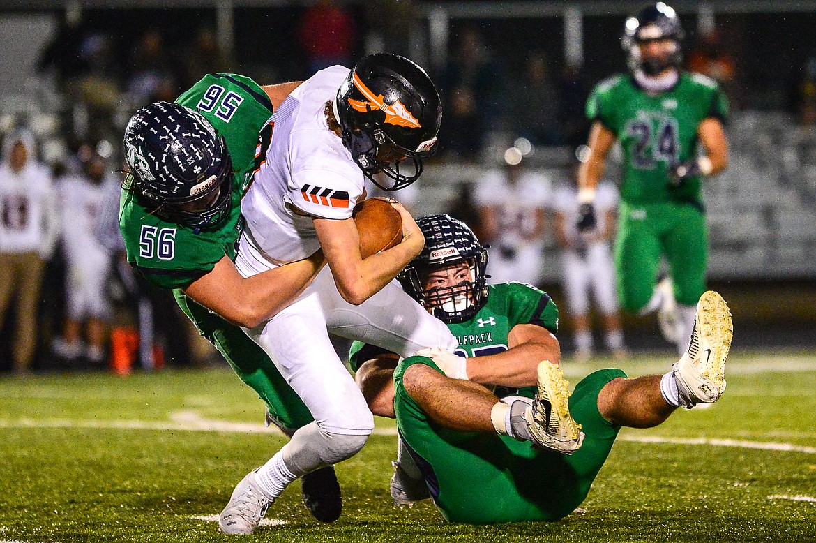 Glacier defenders Rocco Beccari (56) and Jake Rendina (33) sack Flathead quarterback Charlie Hinchey (9) in the third quarter in crosstown football at Legends Stadium on Friday. (Casey Kreider/Daily Inter Lake)