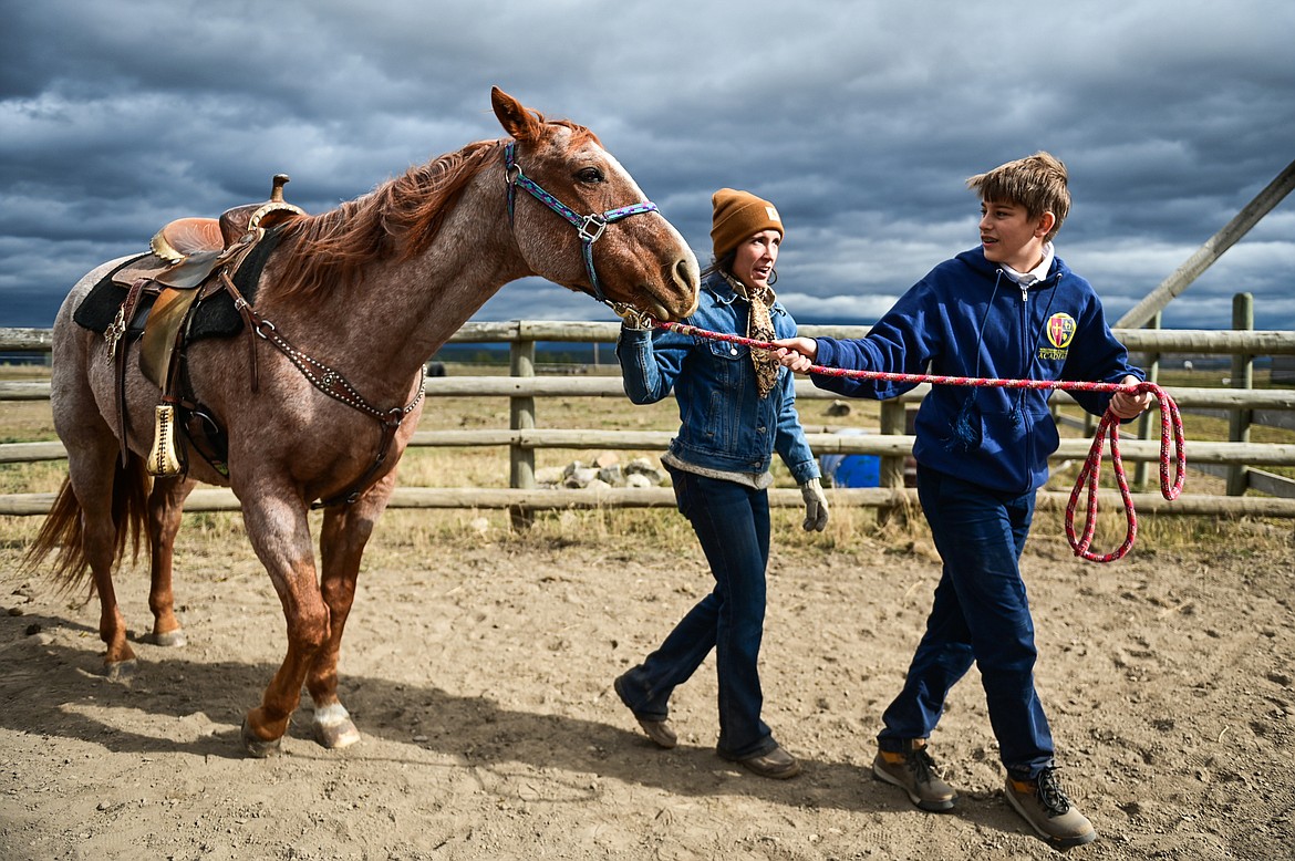 Lost Creek Ranch instructor and owner Chanel Olson shows Whitefish Christian Academy seventh-grader Adrian Raci how to properly lead a horse on Friday, Oct. 15. (Casey Kreider/Daily Inter Lake)