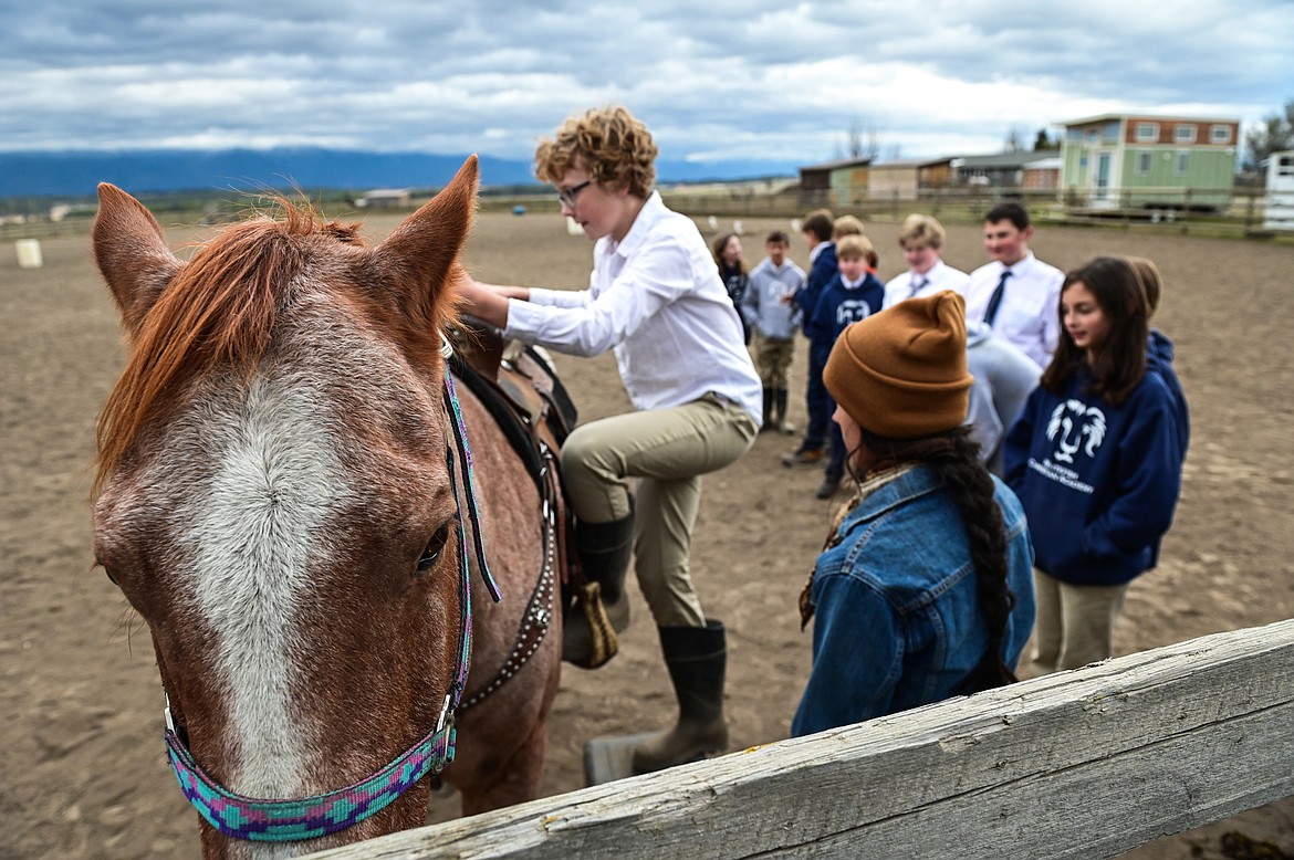 Jack Flink, a seventh-grader from Whitefish Christian Academy, learns how to mount a horse named Hammer from Lost Creek Ranch instructor and owner Chanel Olson on Friday, Oct. 15. (Casey Kreider/Daily Inter Lake)