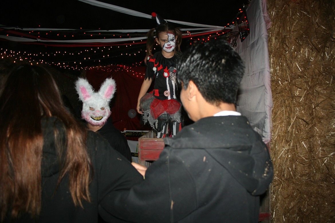 Visitors walk – carefully – through the clown room in the Othello Straw Maze Friday.