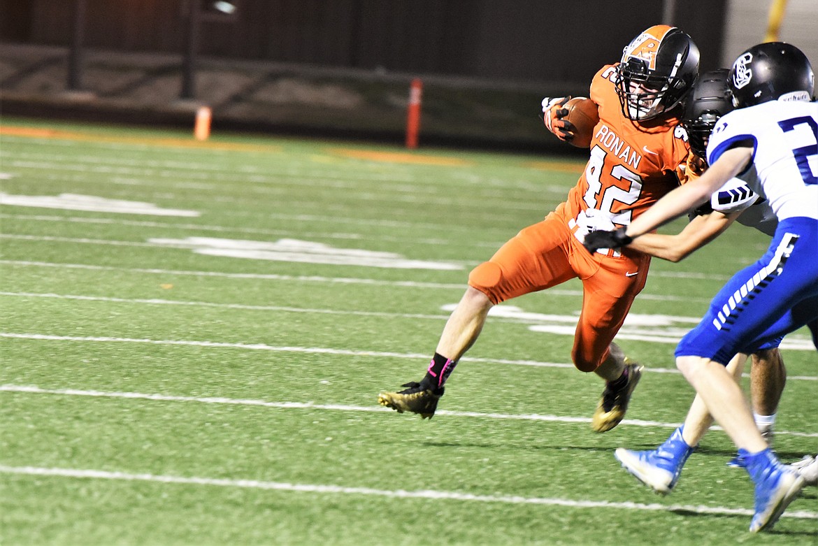 Running back Tristan Fisher heads toward the sideline as the Corvallis defense closes in. (Scot Heisel/Lake County Leader)