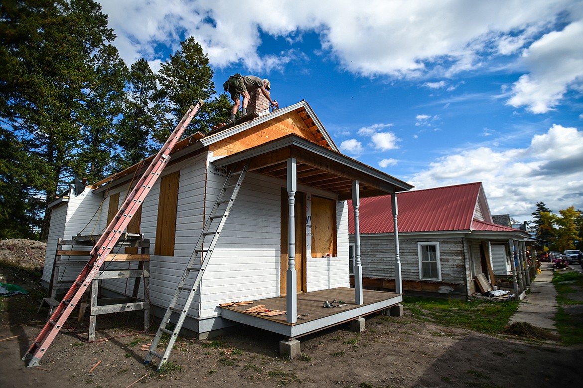 Lee Maxwell works on the roof of a renovation project along Somers Road on Thursday, Sept. 30. Maxwell said the building was originally a schoolhouse for the children of the foremen who worked at the Somers Lumber Company sawmill in the early 1900s. It was later turned into a doctor's office. The house next door with the red roof was the doctor's residence, which he hopes to renovate next. Maxwell specializes in historic renovation projects and has been a builder in the valley for over 30 years.  (Casey Kreider/Daily Inter Lake)