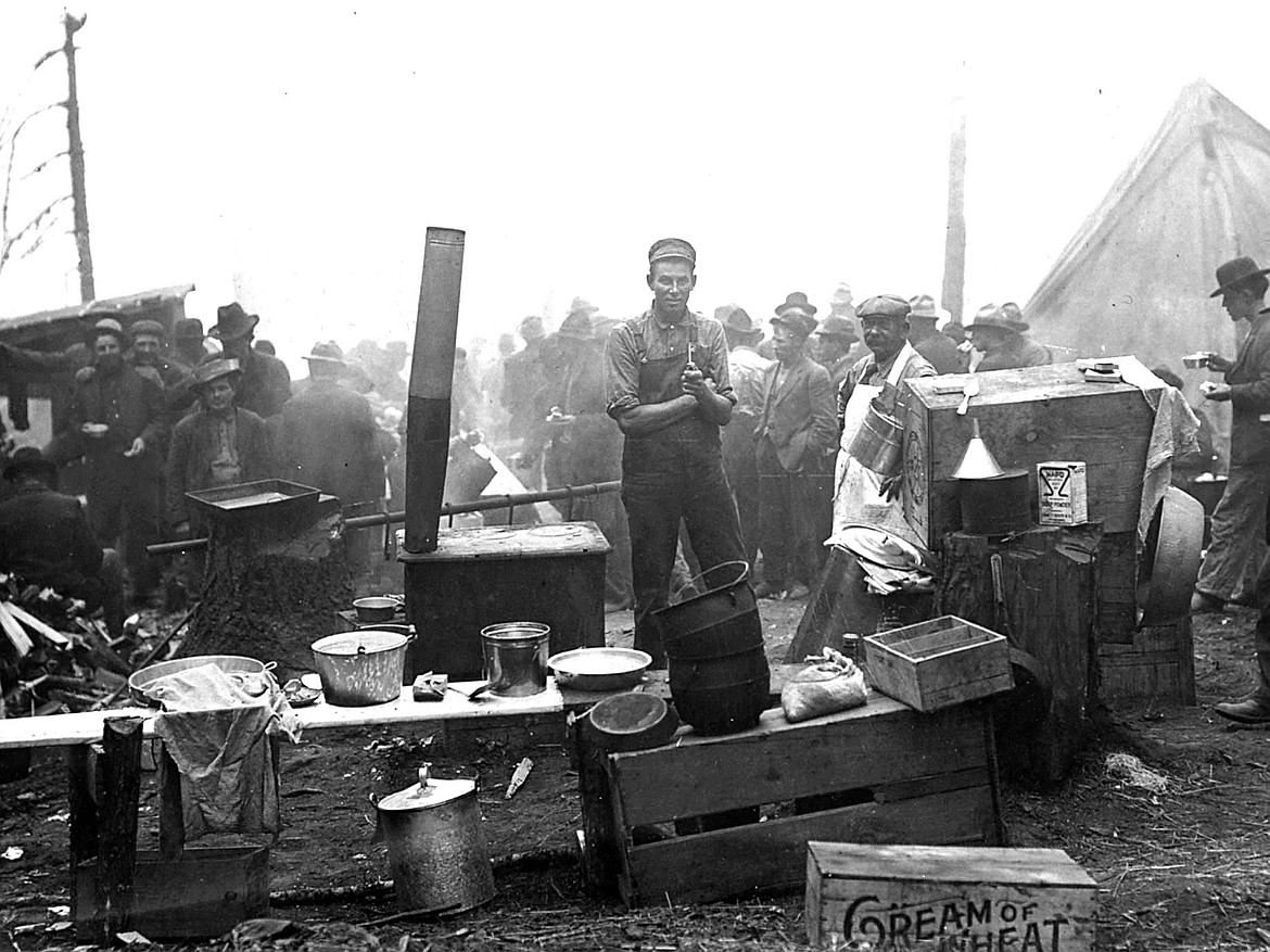 Big Burn 1910 firefighters cooking breakfast at camp, with Pat Grogan wearing an apron, leader of the men who died in the fire at Storm Creek in the Clearwater National Forest.