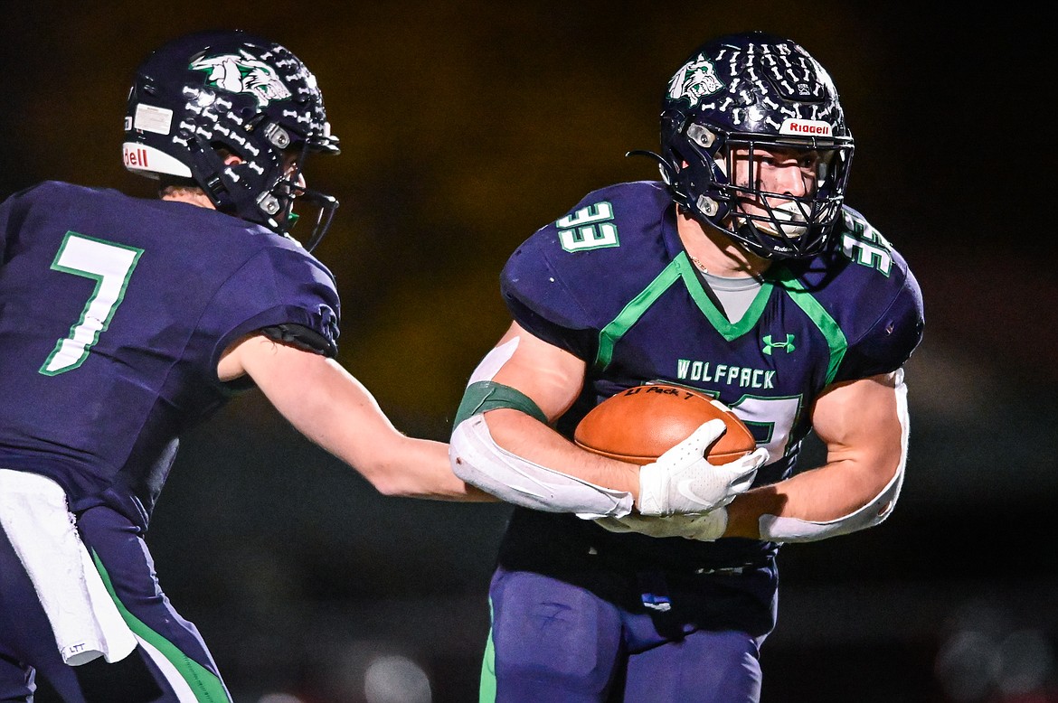 Glacier quarterback Gage Sliter (7) hands off to running back Jake Rendina (33) in the third quarter against Missoula Hellgate at Legends Stadium on Thursday, Oct. 21. (Casey Kreider/Daily Inter Lake)