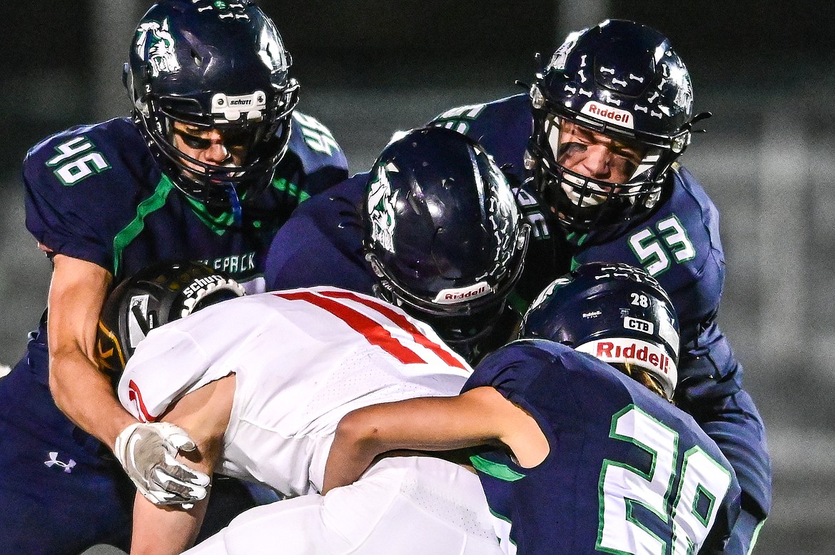 Glacier defenders Royce Conklin (46), Jackson Barney (36), Justin Timlick (53) and Trey Roo (28) wrap up Missoula Hellgate wide receiver Ian Finch (11) in the third quarter at Legends Stadium on Thursday, Oct. 21. (Casey Kreider/Daily Inter Lake)