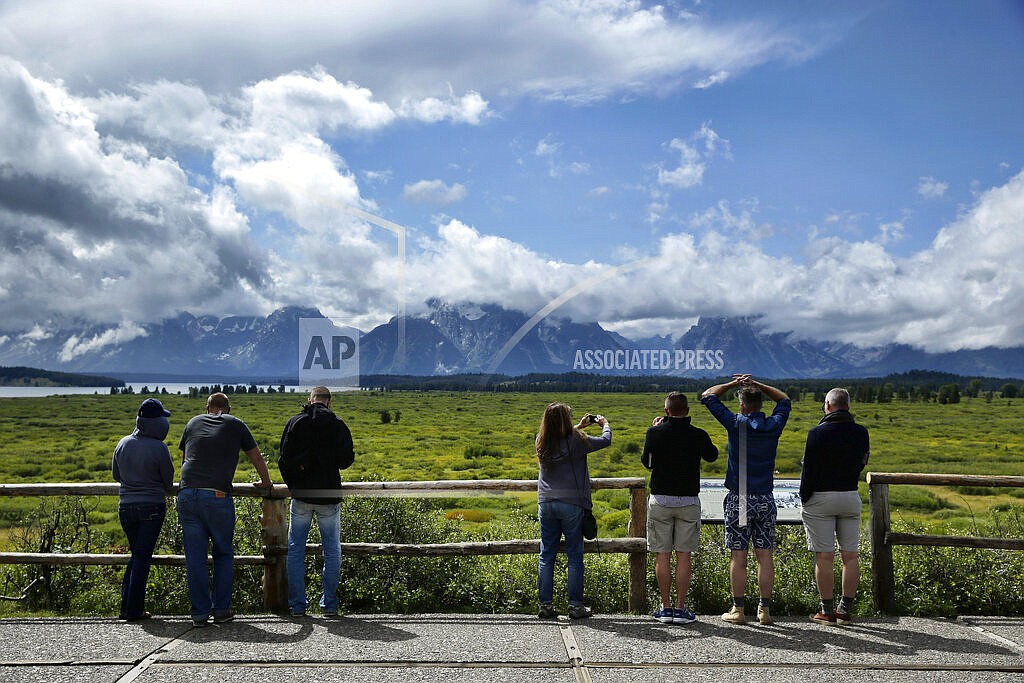 In this Aug. 21, 2014 file photo people look out at the mountains from the Jackson Lake Lodge in Grand Teton National Park near Jackson, Wyo. Just nine months into 2021, Wyoming's Grand Teton National Park already has had its busiest year on record. Grand Teton had almost 3.5 million recreation visits between January and September. The official count of 3,493,937 topped 2018's full-year record by 2,786, park officials said in a statement Wednesday, Oct. 20, 2021. (AP Photo/John Locher, File)