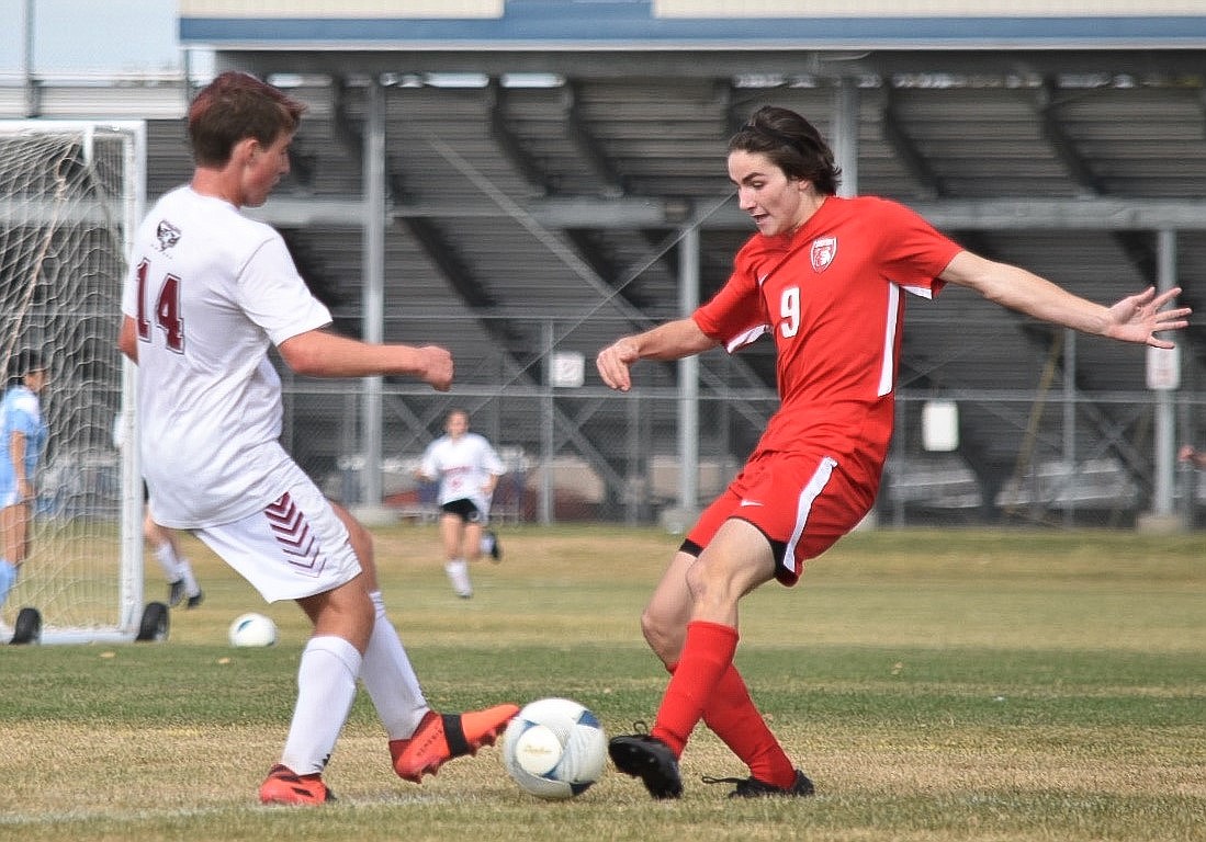 Eoin Eddy vies for the ball with a Canyon Ridge player during Thursday's match. Eddy netted a hat trick.