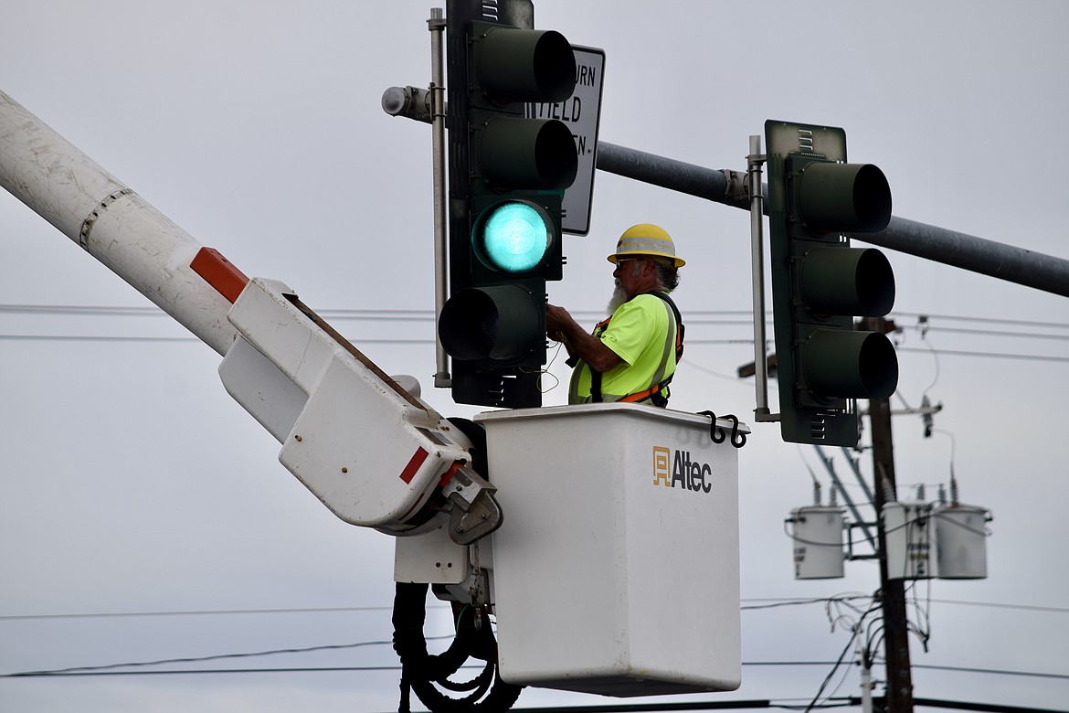 City employee Doug Wraspir replaces a burned-out bulb in a traffic light at the intersection of Third Avenue and Pioneer Way in Moses Lake Wednesday morning.