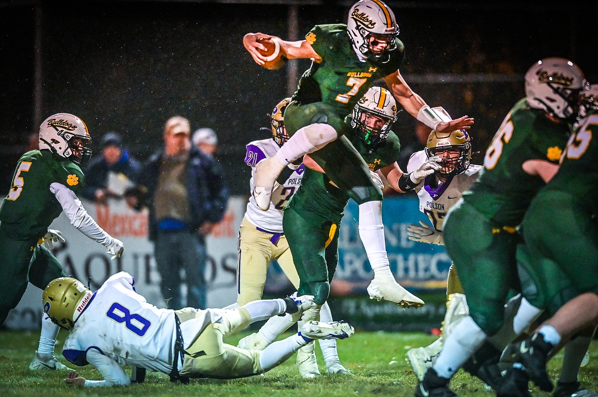 Whitefish quarterback Fynn Ridgeway (7) hurdles Polson defender Jarrett Wilson (8) on a touchdown run in the second quarter at Memorial Field in Whitefish on Friday, Oct. 22. (Casey Kreider/Daily Inter Lake)