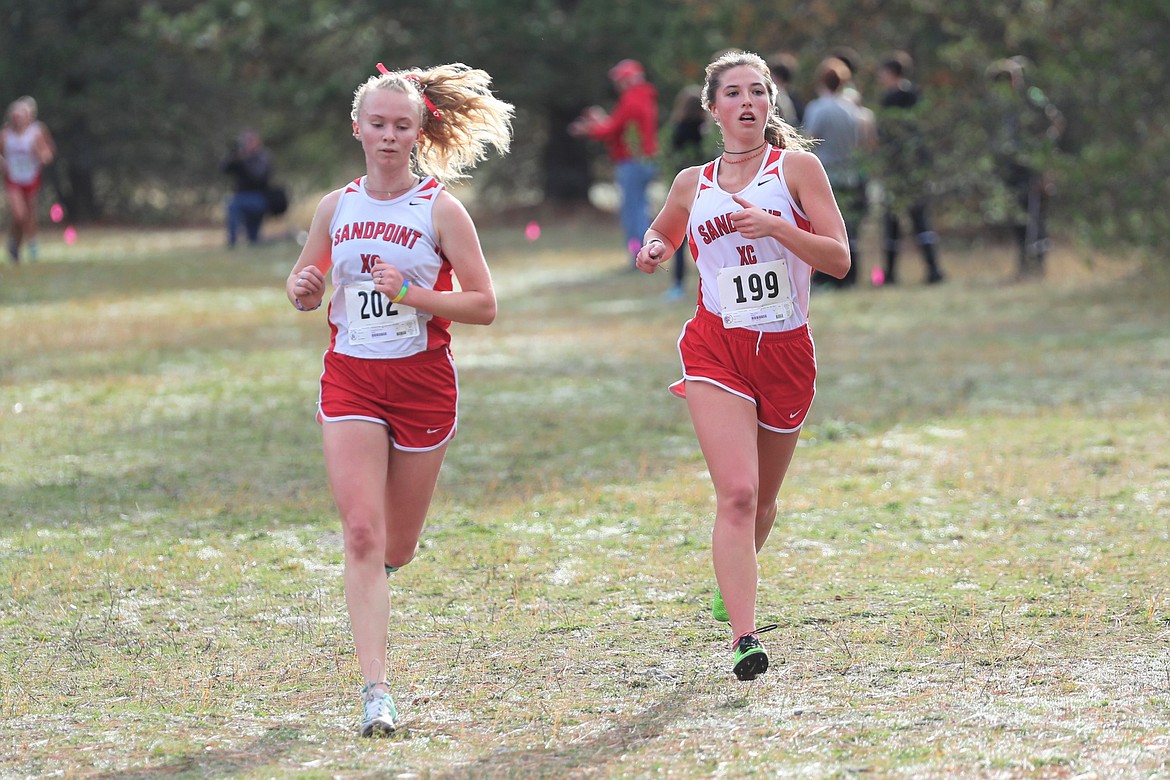 Mackenzie Suhy-Gregoire (left) and Megan Oulman run side-by-side during Thursday's regional meet.