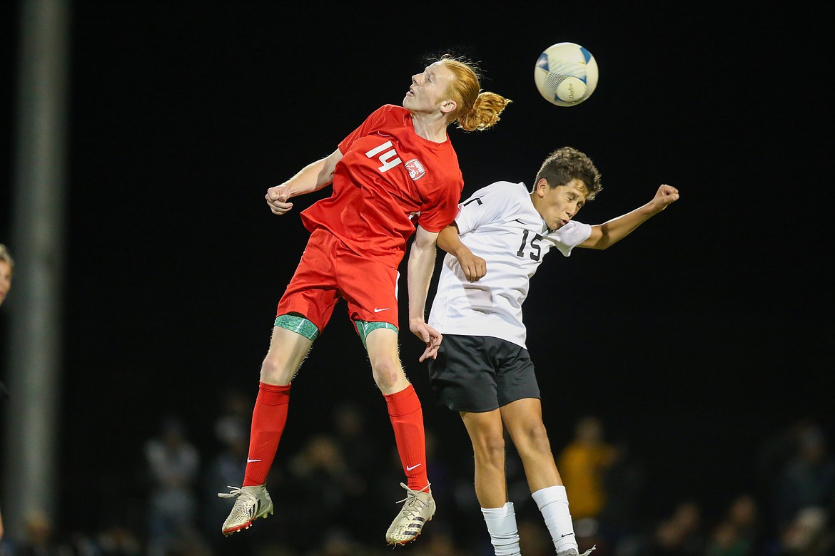 Sandpoint's Canyon Nash (left) rises up for a header over Bishop Kelly's Allan Hurta during Saturday's 4A state title game at Middleton High.