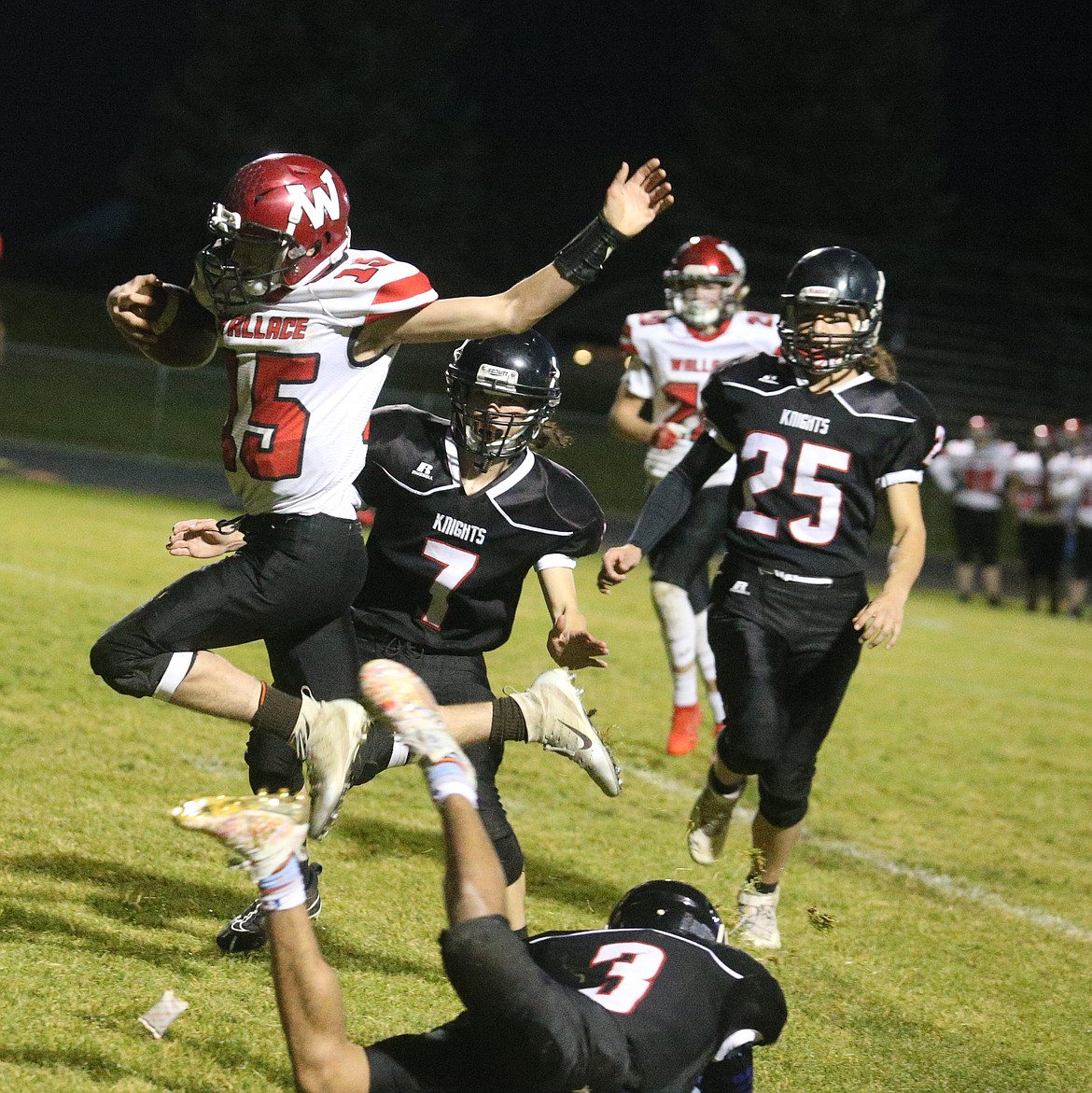 JASON ELLIOTT/Press
Wallace sophomore quarterback Parker Goldade leaps over the tackle of Lakeside junior cornerback Vander Brown during the Scenic Idaho Conference tiebreaker at Post Falls High on Monday.