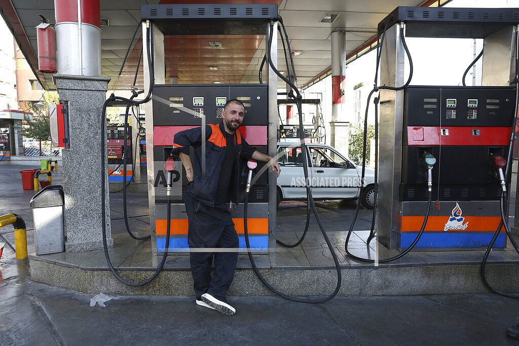 A worker leans against a gasoline pump that has been turned off, at a gas station in Tehran, Iran, Tuesday, Oct. 26, 2021. Gas stations across Iran on Tuesday suffered through a widespread outage of a system that allows consumers to buy fuel with a government-issued card, stopping sales. One semiofficial news agency referred to the incident as a cyberattack. (AP Photo/Vahid Salemi)