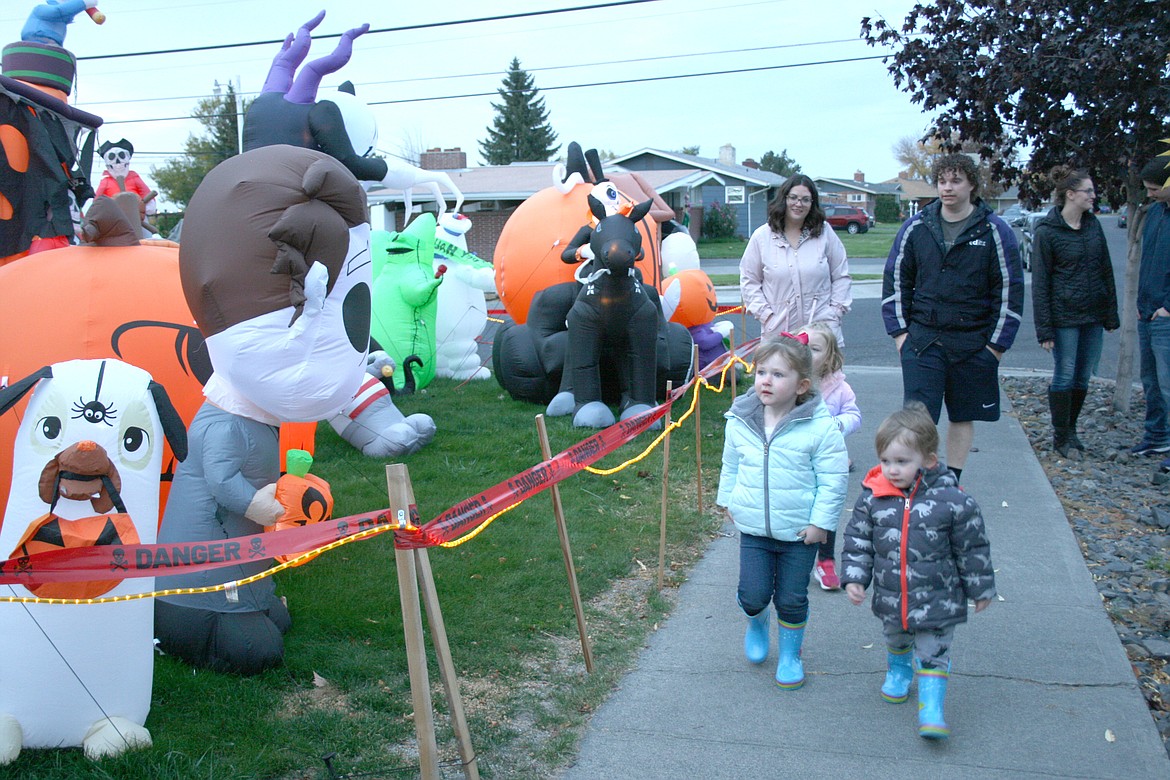 At right, Ellianna Morris (left) and her brother Carston Morris (right) are in the lead as their family and friends check out the display of Halloween decorations at the home of James Hash at 2104 S. Crestmont Drive in Moses Lake. (That’s family friend Hayden Brown partially obscured, and Ellianna and Carston’s mom and dad, Jessica and Anthony Morris, in the rear, with Cassie Brown at far right.) 
James Hash said he’s been filling his yard with Halloween decorations for about four years.