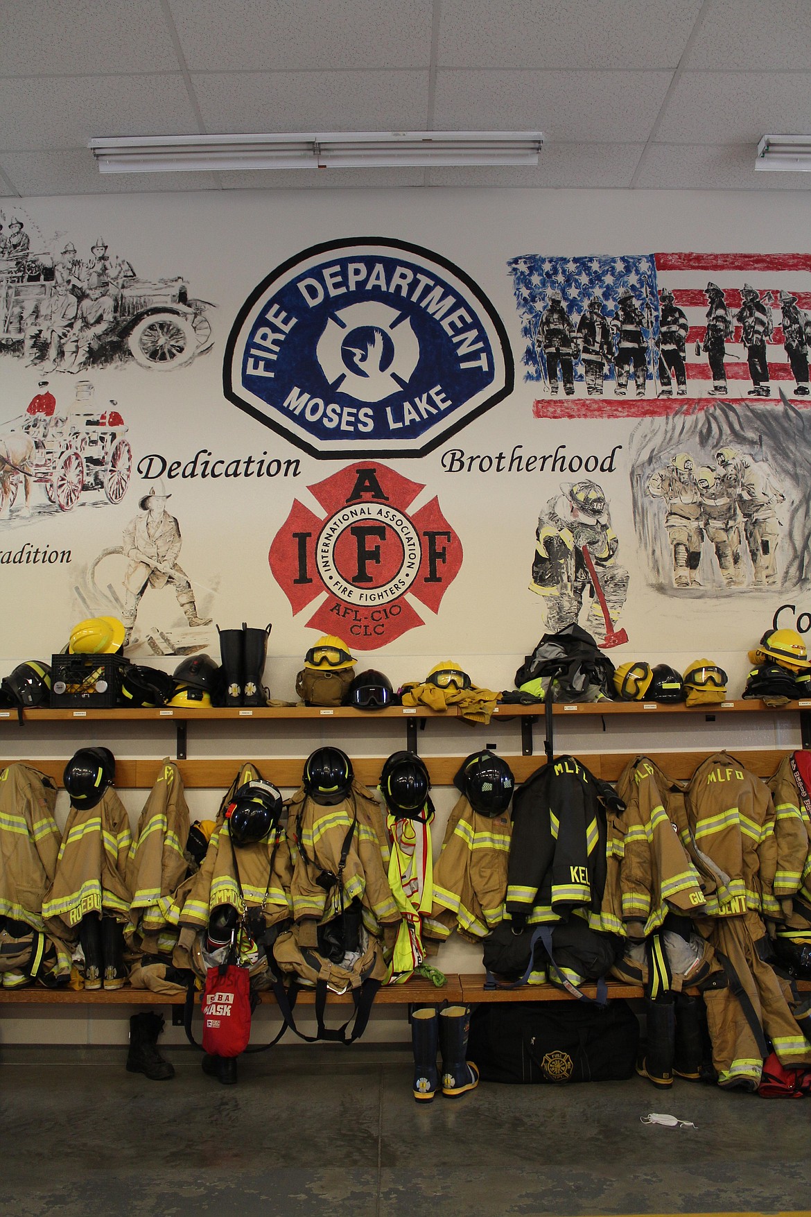 Gear lines a wall with paintings by a former firefighter in the Moses Lake Fire Department’s truck bay.