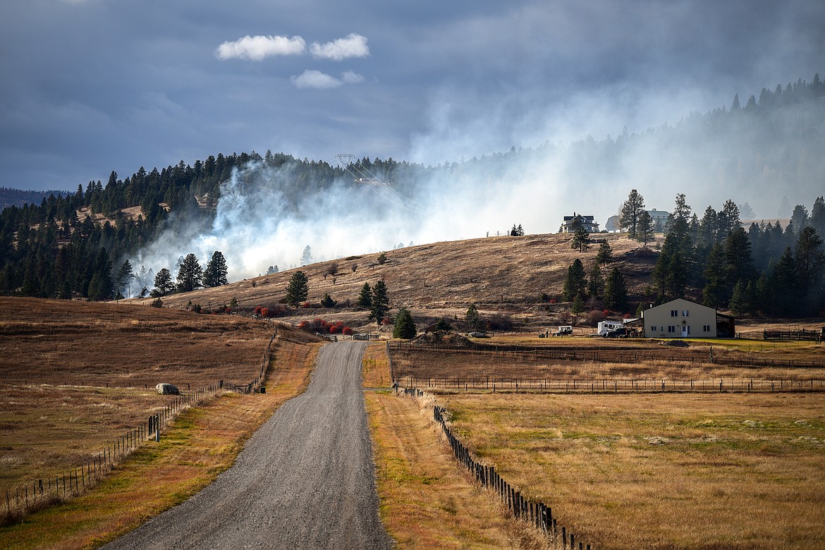 A grass fire burns on a hillside off West Valley Drive near U.S. Highway 2 West in Kalispell on Wednesday, Oct. 27, in this view looking down Armstrong Lane. A fire tanker from Smith Valley Fire Department was driving back and forth on West Valley Drive monitoring the fire. (Casey Kreider/Daily Inter Lake)