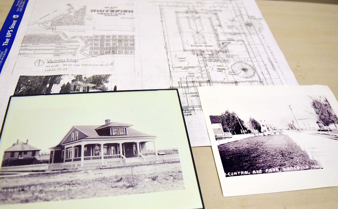 A historic photo of the Houston home, at left, sits on a table along with blueprints outlining the restoration plans for the home and a historic photo of Central Avenue on a table in the dining room of the house. (Heidi Desch/Whitefish Pilot)