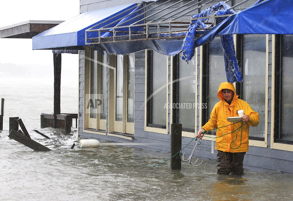 A worker retrieves a grappling hook on the dock next to Bubba's restaurant on the water in Virginia Beach, Va., Monday, Oct. 29, 2012. Voters in Virginia Beach will consider whether to vote for a $500 million bond on election day that would be used for protection against flooding from rising seas and intensifying hurricanes.(AP Photo/Steve Helber)