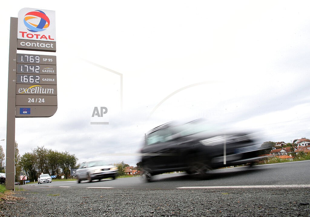 Cars pass by a gas station in Saint Jean de Luz, southwestern France, Friday, Oct. 22, 2021. When they gather for their first post-pandemic summit, leaders of the Group of 20 countries will confront a global recovery that's encountering unexpectedly persistent headwinds: A global energy crunch bringing higher fuel and utility prices, allegedly temporary consumer inflation that might hang around longer than first thought, and bottlenecks in supply chains that keep the global economy humming and goods headed to customers. (AP Photo/Bob Edme, File)