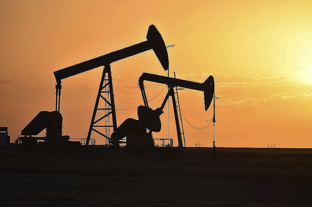 Pump jacks extract oil from beneath the ground east of New Town, N.D., on May 19, 2021.