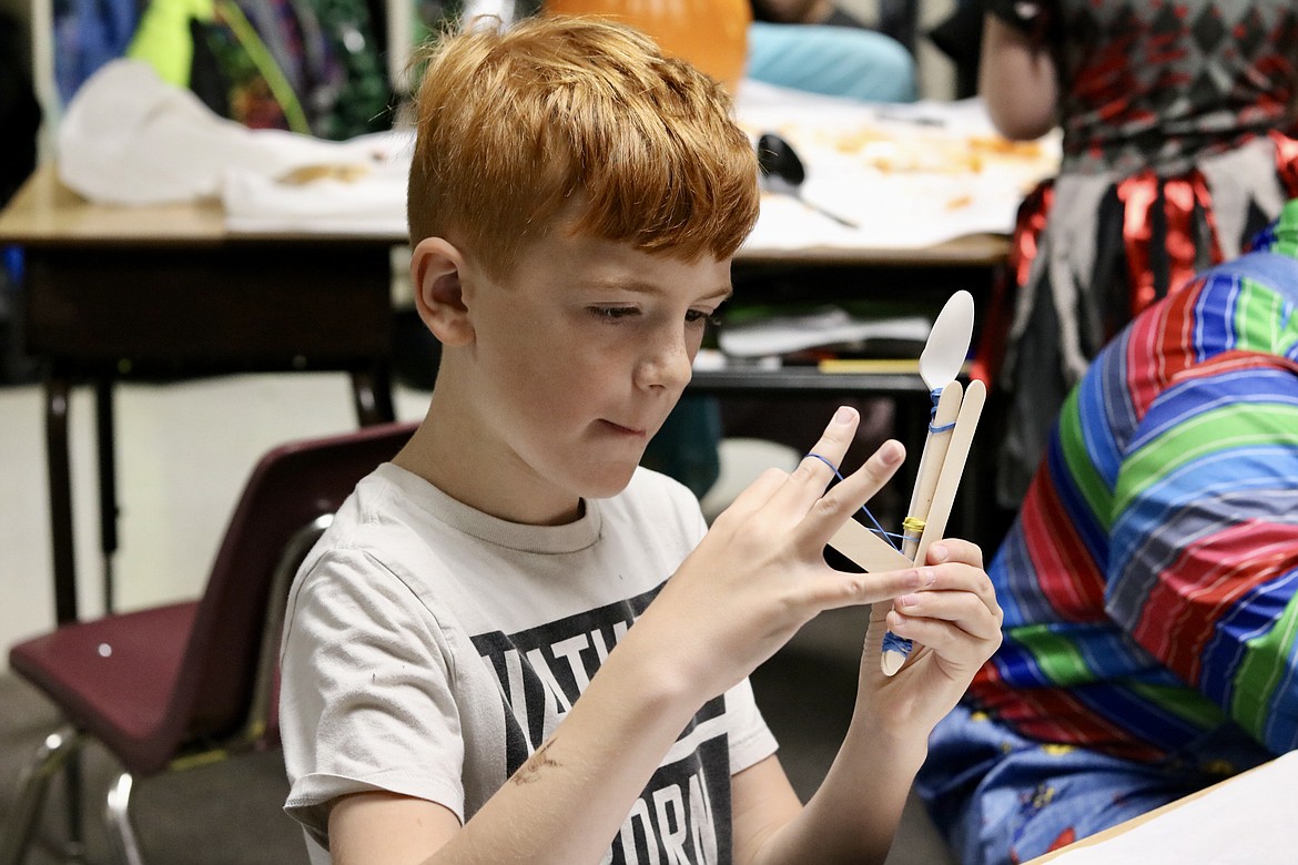 Fourth grader Hunter Schwieters creates a catapult as part of the Halloween-themed STEM activities at Fernan STEM Academy in Coeur d'Alene on Friday. HANNAH NEFF/Press