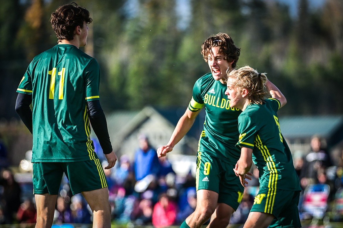 Whitefish's Collin Lyman (11), Gabe Menicke (9) and Chase Sabin (3) celebrate after Menicke's goal in the first half against Columbia Falls in the State A championship at Smith Fields on Saturday, Oct. 30. (Casey Kreider/Daily Inter Lake)