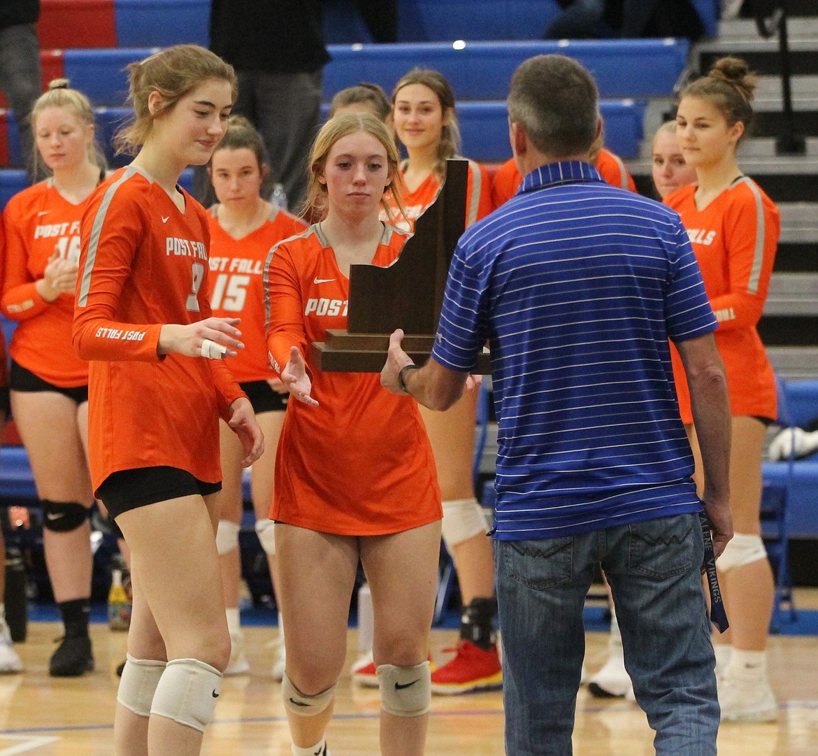 MARK NELKE/Press
Rylee Hartwig, left, and Kassie Gardiner of Post Falls accept the fourth-place trophy from tournament director and Coeur d'Alene High athletic director Bill White on Saturday after losing to Eagle at the state 5A volleyball tournament at Coeur d'Alene High.