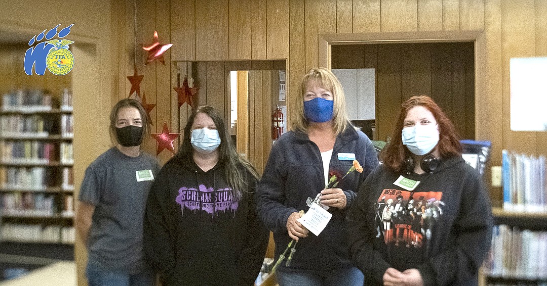 One recipient of a bouquet of flowers on Oct. 20 was Warden City librarian Jean Russell. From left to right: Kenna Cox, Caitlynn Berry, Russell and Ashlynn Berry.