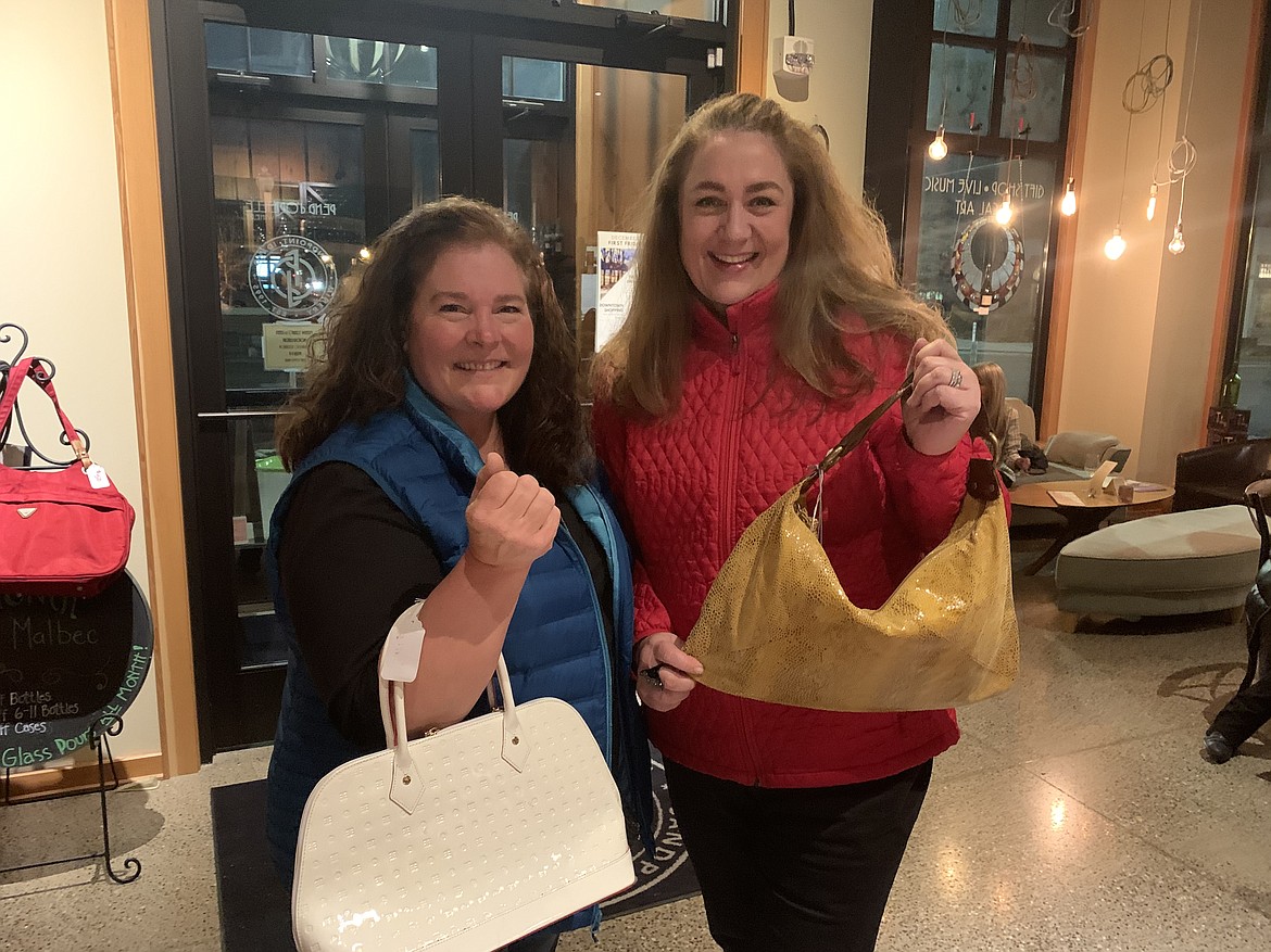 A pair of shoppers show off their finds at a past Purse Party fundraiser. The event, which raises money for North Idaho CASA, will be held in mid-November.