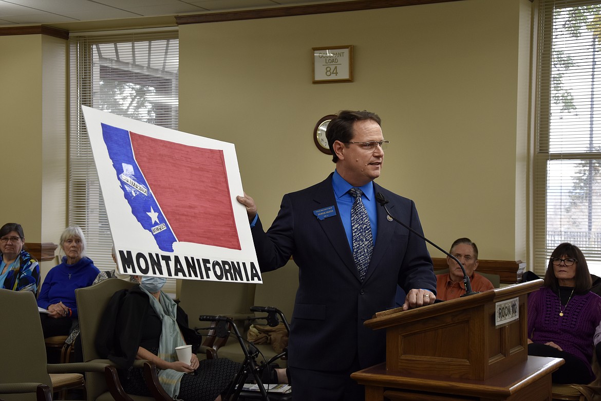 Montana State Rep. Derek Skees, a Republican from Kalispell, holds up a map labeled "Montanifornia" while commenting on proposed maps dividing the state into two congressional districts during a redistricting commission meeting in Helena, Mont. on Saturday, Oct. 30, 2021. Skees used the map to argue against proposals that would keep Democratic stronghold cities Missoula and Bozeman in a western congressional district. (AP Photo/Iris Samuels)
