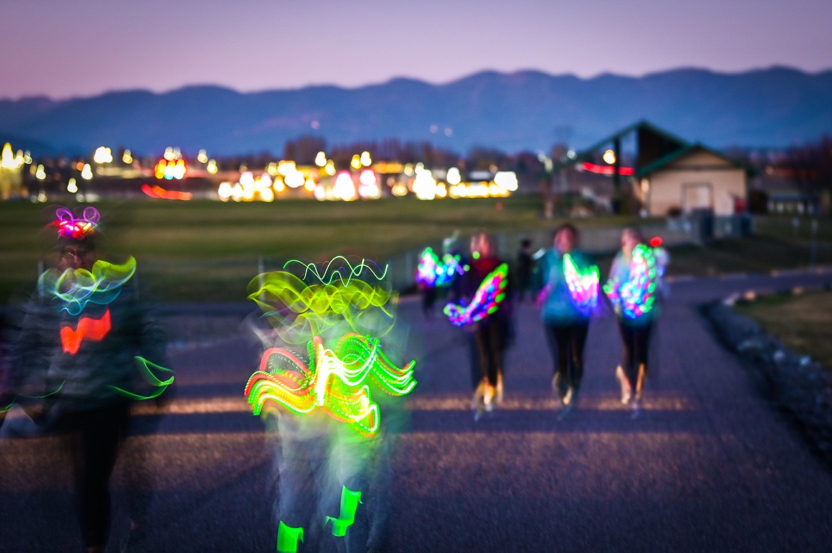 Shot with a slow shutter speed, participants make their way around Kidsports Complex during the Glow Run to raise money for the Nate Chute Foundation on Saturday, Oct. 30. (Casey Kreider/Daily Inter Lake)