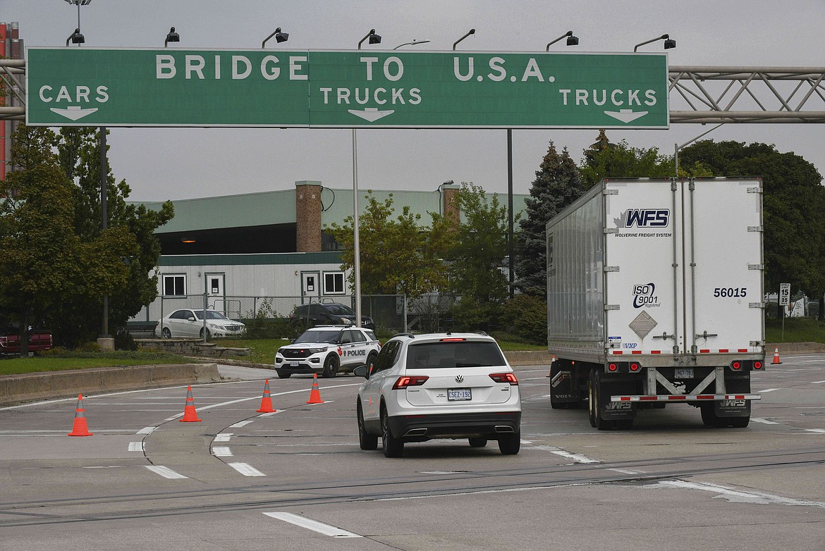 In this Oct. 4, 2021, file photo, traffic moves towards a police car by the Ambassador Bridge border crossing in Windsor, Ontario, Canada.