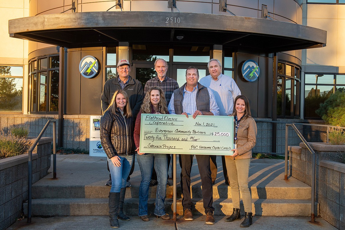 Flathead Electric Cooperative Communications & Marketing Supervisor Katie Pfennigs, front right, presents check to Evergreen Community Partners Board Members (back row) Charles Lapp, BJ Lupton, TJ Wendt, (front row) Sarah Stahlberg, Daren Engellant, and Darla Harmon. (Courtesy photo)