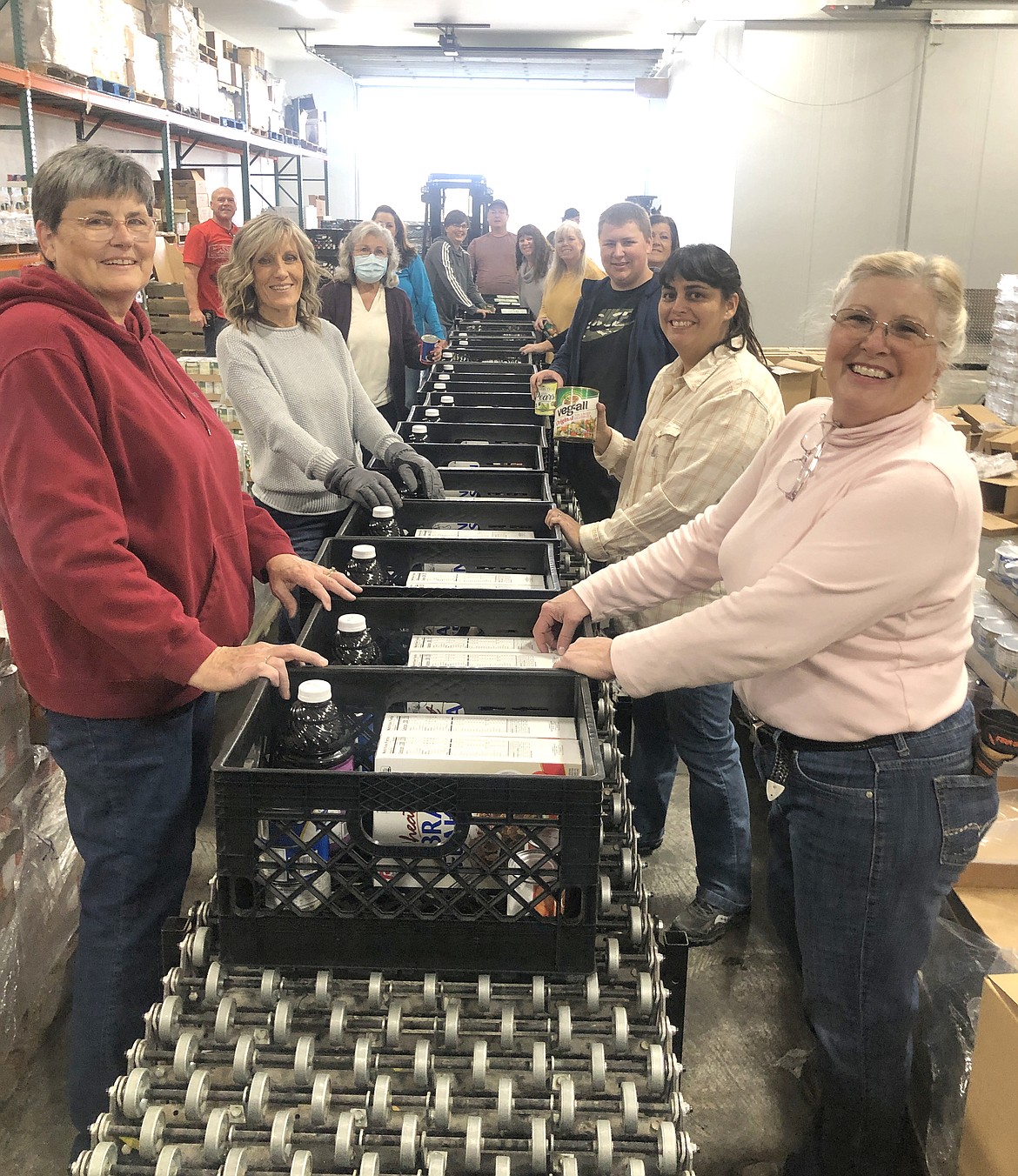 Members of The Church of Jesus Christ of Latter-day Saints form an assembly line to put together food boxes for the Senior 850 project.