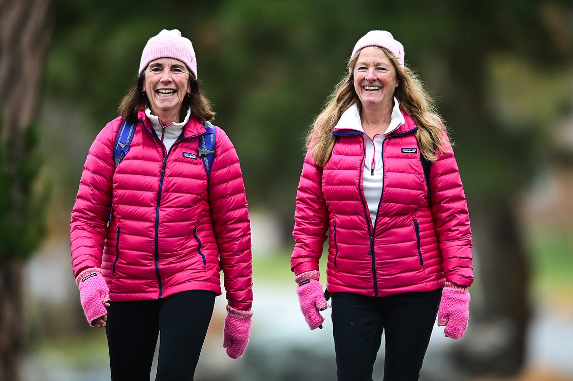 Julia Sunde, left, and Nancy Goodson are shown along Lakeside Boulevard during their 14-mile walk between Somers and Lakeside on Tuesday, Nov. 2. Sunde and Goodson walk a mile for each year that Sunde has been cancer free. The pair started at Somers Bay Cafe and walked to Conrad Point on Flathead Lake, turned around and headed back to Volunteer Park and ended at Tamarack Brewing Company for lunch. (Casey Kreider/Daily Inter Lake)