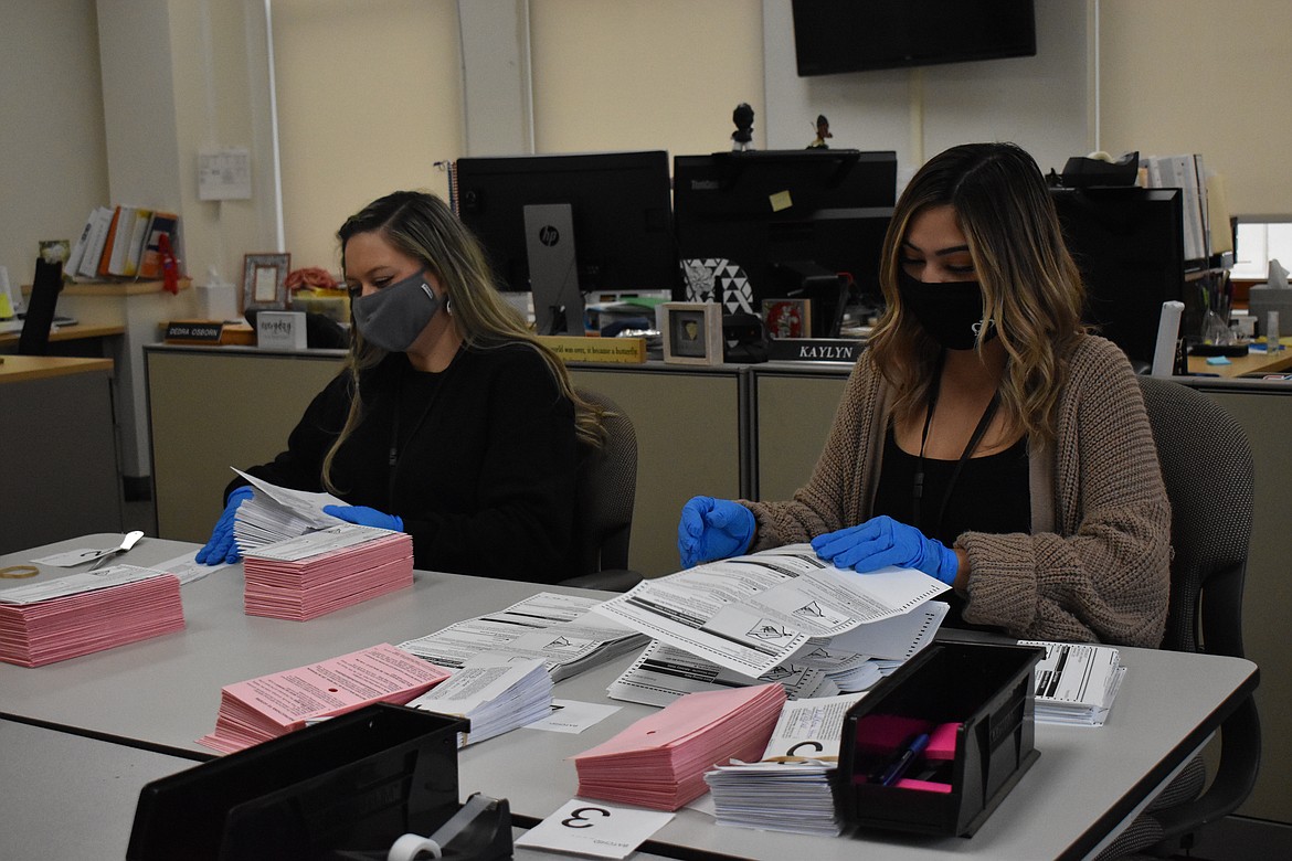 Aleanah Lopez, left, and Kaylyn Orozco, right, go through ballots at the Grant County Elections Office on Tuesday. They are responsible for opening and counting the ballots before checking for write-ins, and properly filled-in bubbles, so the machine can read them.