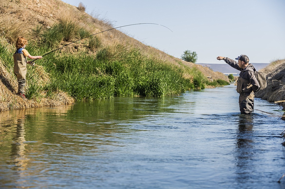 Joshua Shew (right), gives a fly fishing lesson. Shew says he wants his business, Shewfly Lessons, to be an economical alternative for people learning to fly fish.