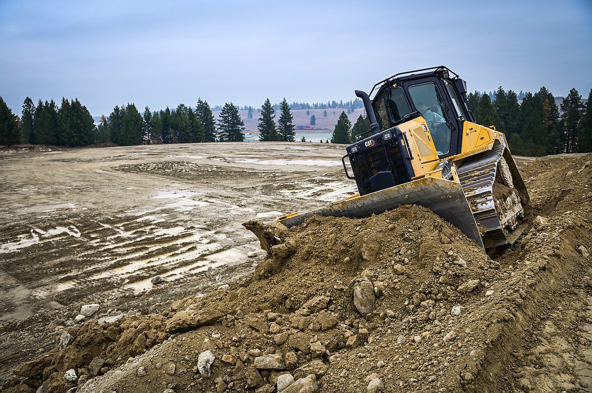 A bulldozer grades dirt along a berm overlooking what will become the first base line of a baseball stadium for Kalispell's new Pioneer League team located at the former site of Montana Raceway Park along Highway 93 on Wednesday, Nov. 3. (Casey Kreider/Daily Inter Lake)