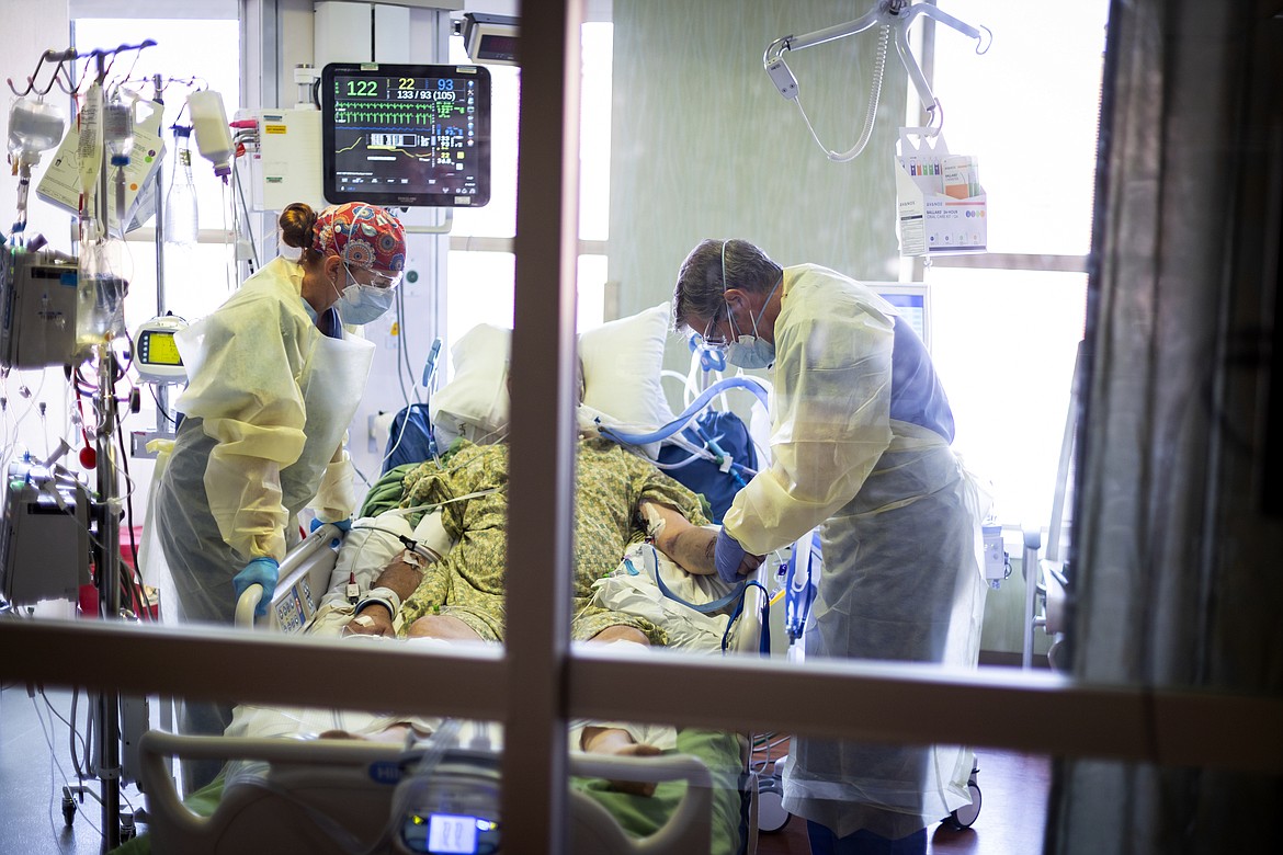 Dr. William Dittrich M.D. looks over a COVID-19 patient in the Medical Intensive care unit (MICU) at St. Luke's Boise Medical Center in Boise, Idaho, Aug. 31, 2021. The rate of COVID-19 hospitalizations and newly confirmed coronavirus cases has been dropping in Idaho, but the numbers are still high enough to leave hospitals overtaxed, Idaho Division of Public Health Administrator Elke Shaw-Tulloch said Tuesday, Nov. 2, 2021. (AP Photo/Kyle Green, File)
