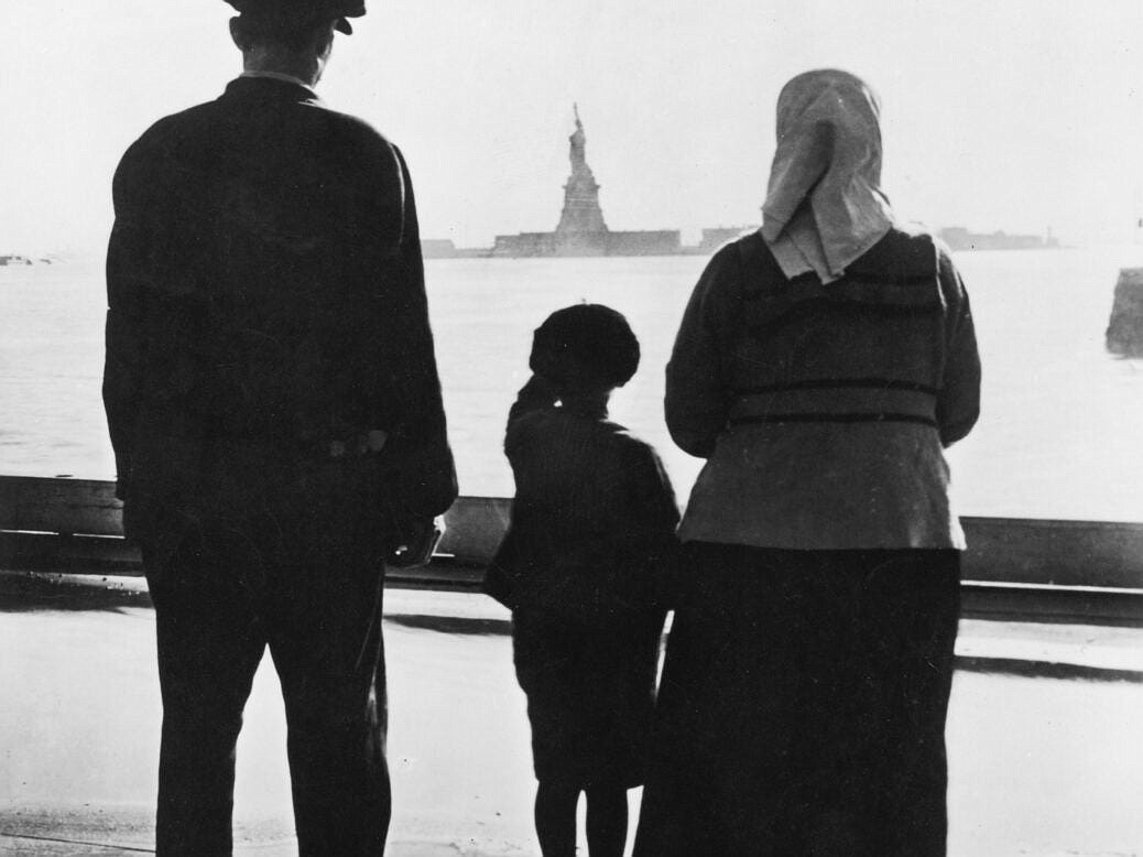 Immigrant ship sailing past Statue of Liberty.